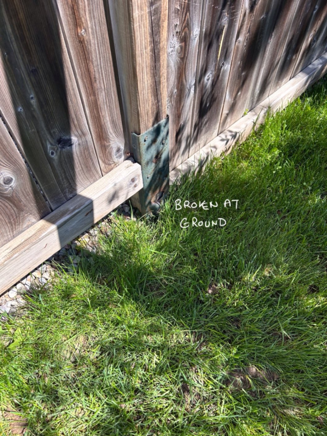 A rusted mender plate still screwed to a post our crew marked BROKEN AT GROUND — the plate outlived the post it was meant to save — Ontario, June 2026.