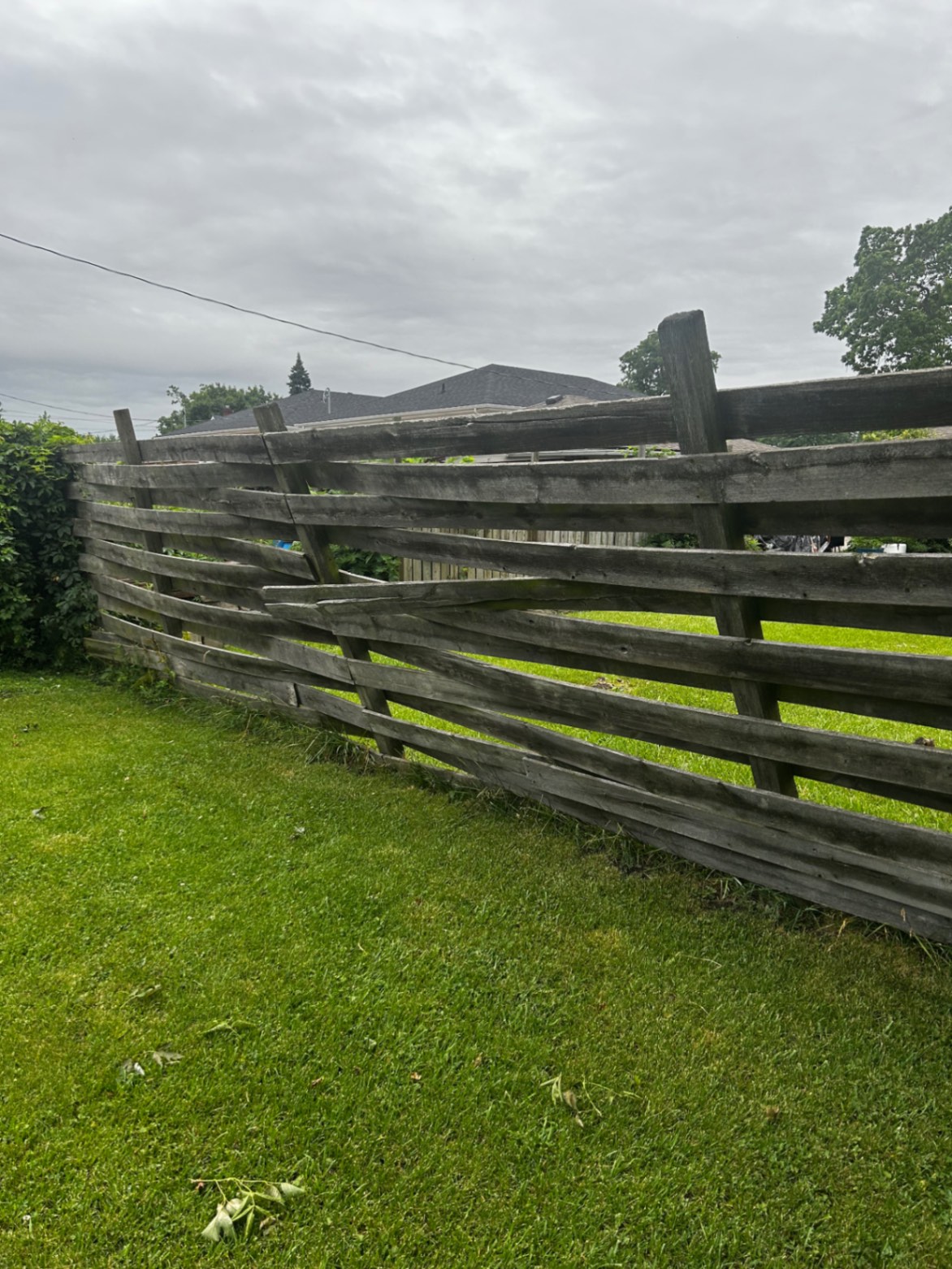 Customer-submitted photo of a failing fence estimated at 15+ years old (example 2)